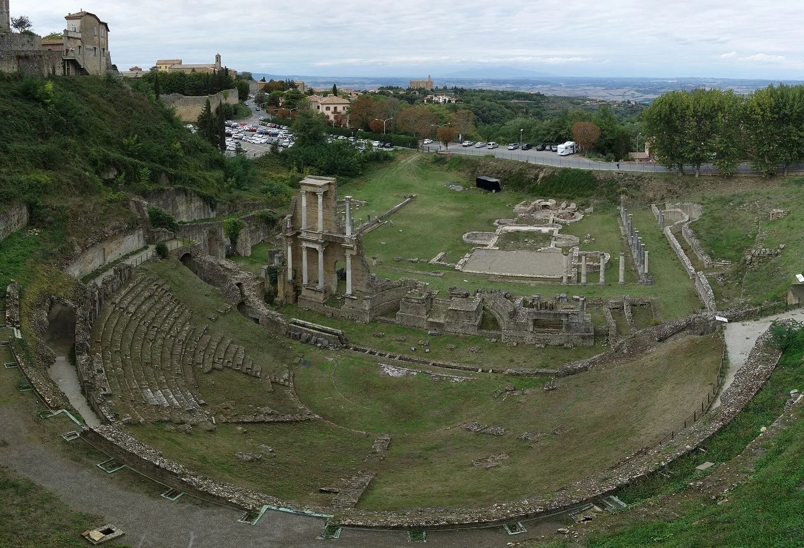 Veduta dall'alto del teatro romano di Volterra: le gradinate a semicerchio, le colonne della scena e la campagna toscana sullo sfondo